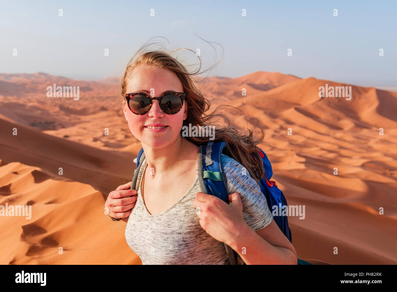 Escursionista femmina su una rossa duna di sabbia nel deserto, paesaggio di dune Erg Chebbi, Merzouga, Sahara, Marocco Foto Stock