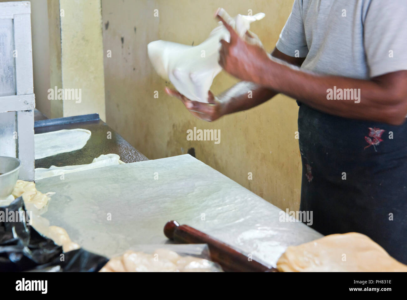 Ritratto orizzontale di un uomo che fa tradizionale pane azzimo in Sri Lanka. Foto Stock