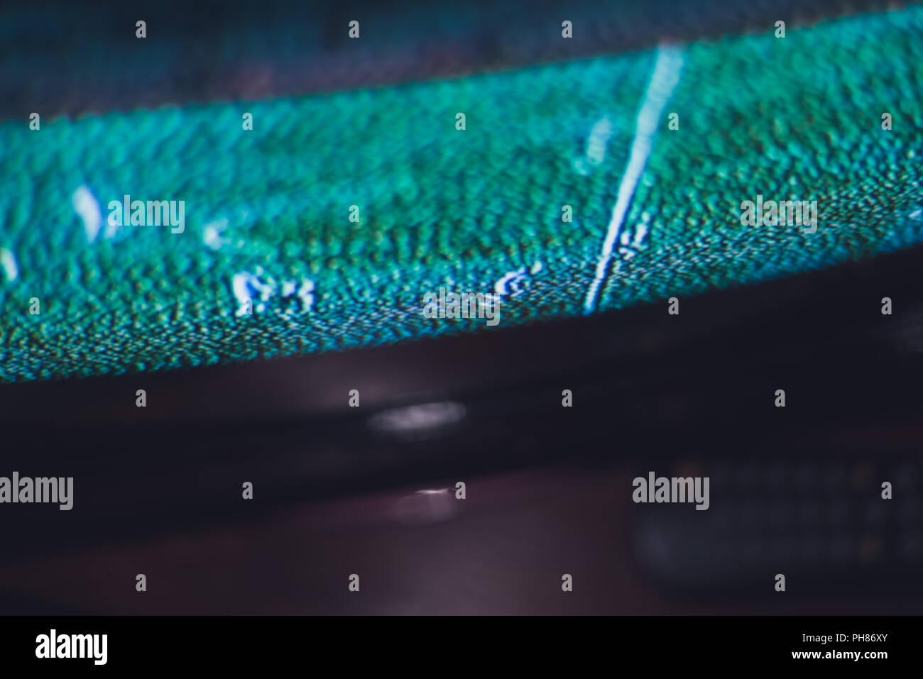 TV basso segnale sfocato sfondo astratto. Schermo TV e un telecomando nelle tenebre. La profondità di campo ridotta. Foto Stock