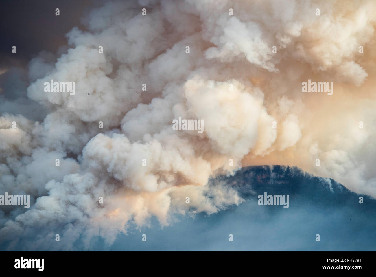 Elicottero nei pennacchi di fumo a rischio di incendio la riduzione a monte solitario, Blue Mountains, Australia Foto Stock