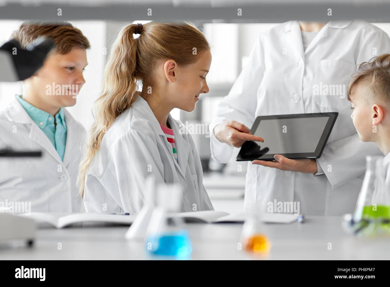 Insegnante con tablet pc e i bambini in chimica classe Foto Stock