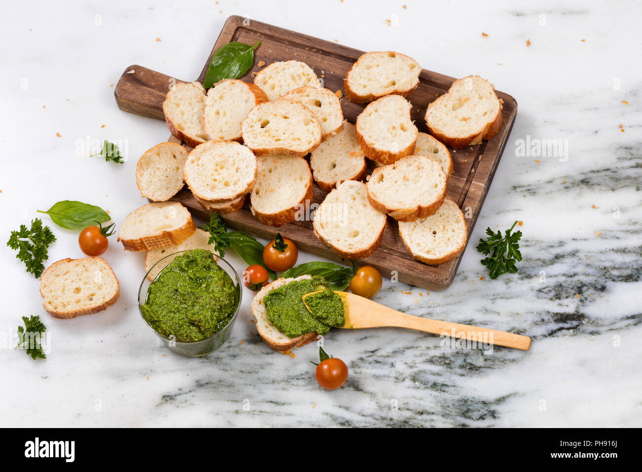 Preparata di fresco pesto e fette di pane sul server in legno Foto Stock