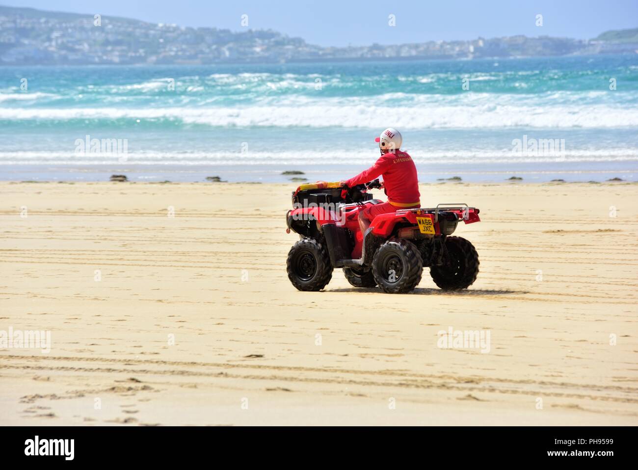 ATV quad bike essendo cavalcato da un bagnino RNLI,Riviere Towans beach,Riviere Towans beach, Phillack, Hayle,cornwall,l'Inghilterra,UK Foto Stock