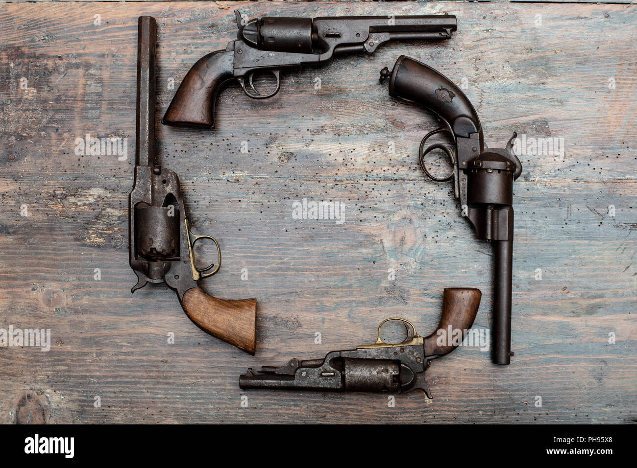 Collezione di pistole vintage vintage sul tavolo di legno con lo spazio di testo al centro Foto Stock