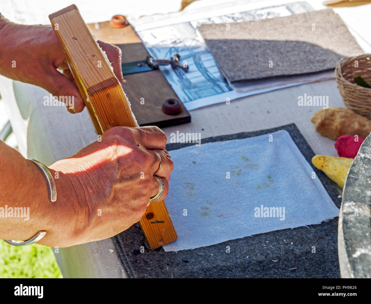 Una dimostrazione di semplice produzione di carta. Il ribaltamento della stuoia umida su di una superficie di tessuto di essiccazione e pressatura in un foglio di carta. Foto Stock