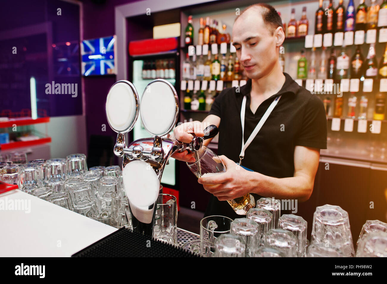 Il barista versa una birra al bar del club Foto Stock