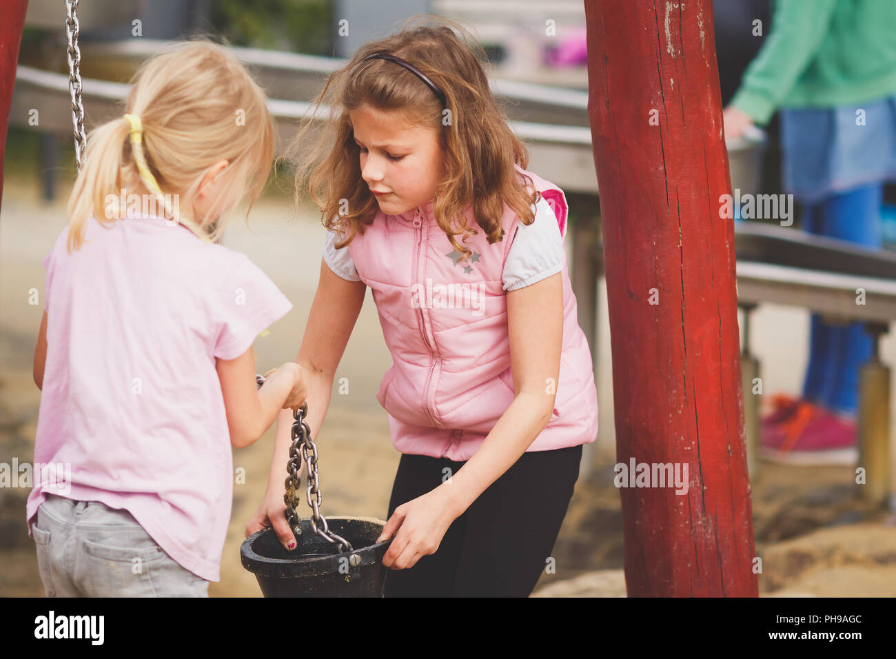 Le giovani ragazze a giocare con sabbia compresi sul parco giochi Foto Stock
