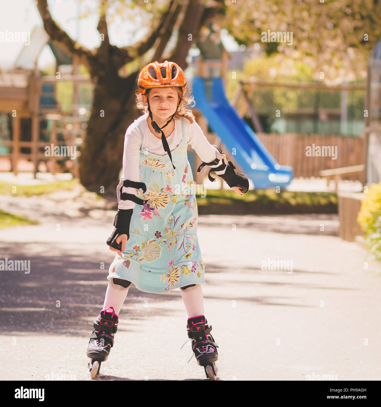 Ragazza giovane learning pattinaggio con pattini a rotelle in linea Foto Stock