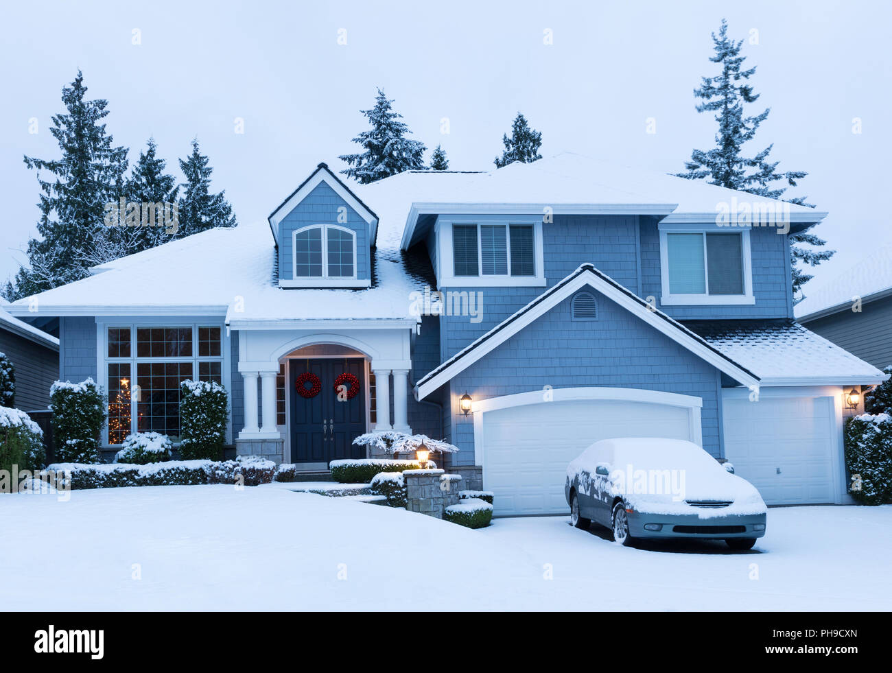Casa decorata per le vacanze invernali con neve fresca Foto Stock