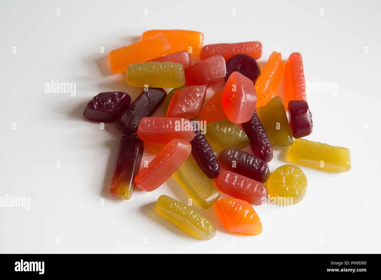 Un mucchio di multi colore gomma vini dolci seduti su uno sfondo bianco Foto Stock