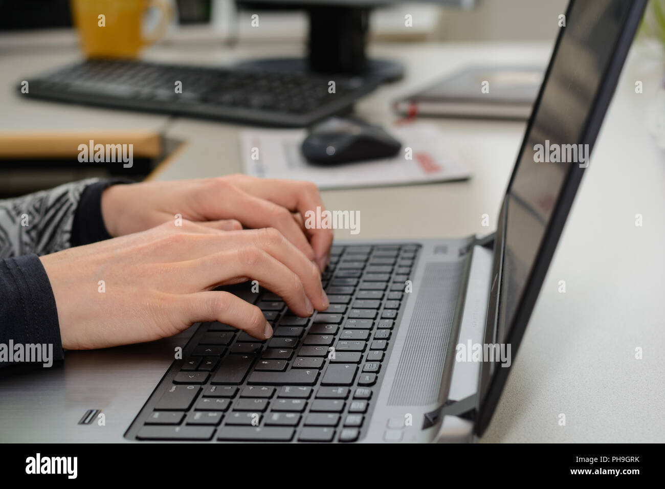 Lavoratore di ufficio digitando sulla tastiera di un computer portatile - close-up Foto Stock