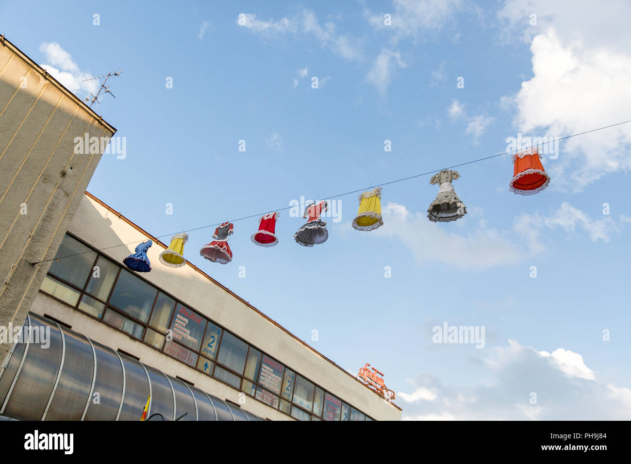 Un display di abiti colorati appeso sopra le strade di Krosno città in Polonia durante i climi dei Carpazi Festival. Foto Stock