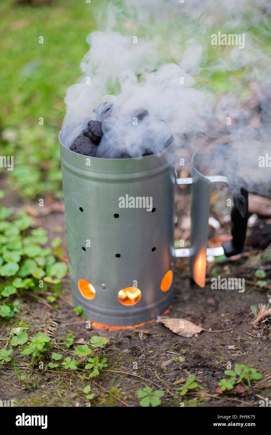 La cottura su carbone di legna prima di barbecue a carbone di legna camino motorino di avviamento Foto Stock