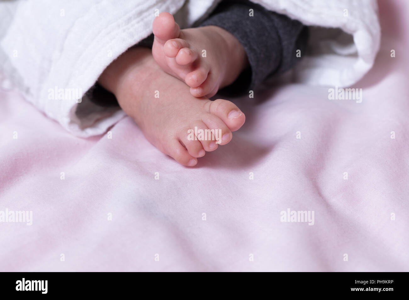 Piedi del bambino fuori da sotto la calda coperta Foto Stock