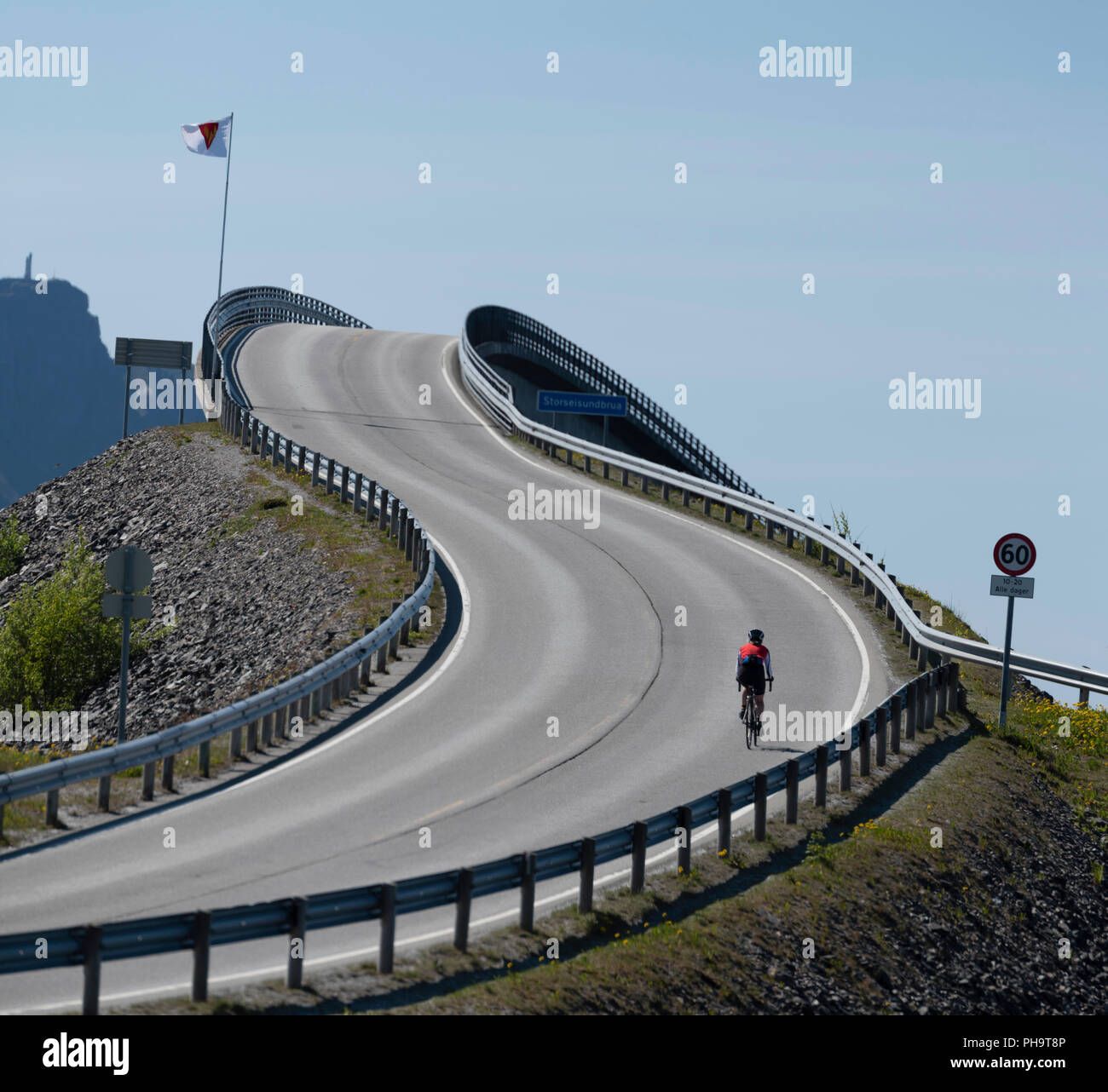 Ciclista femmina rampicante dei ponti sulla famosa strada atlantica, Norvegia. Foto Stock