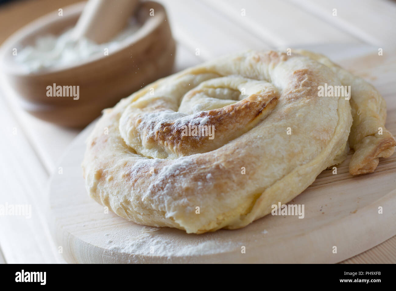 Pane appena sfornato a spirale torta di formaggio sul piatto di legno Foto Stock