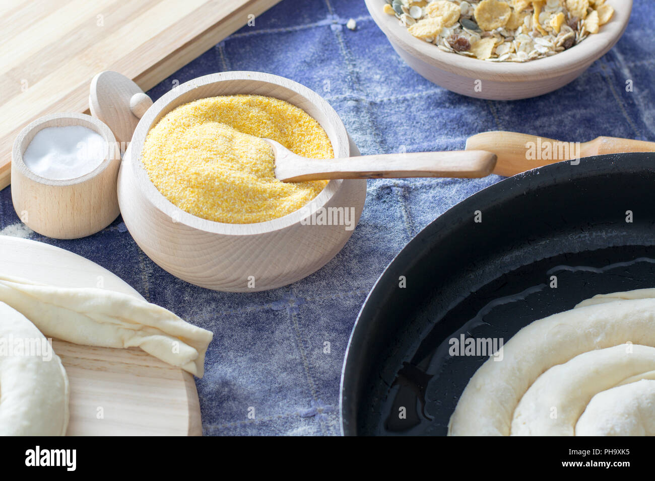La farina di mais nella ciotola di legno con il cucchiaio di legno. Foto Stock