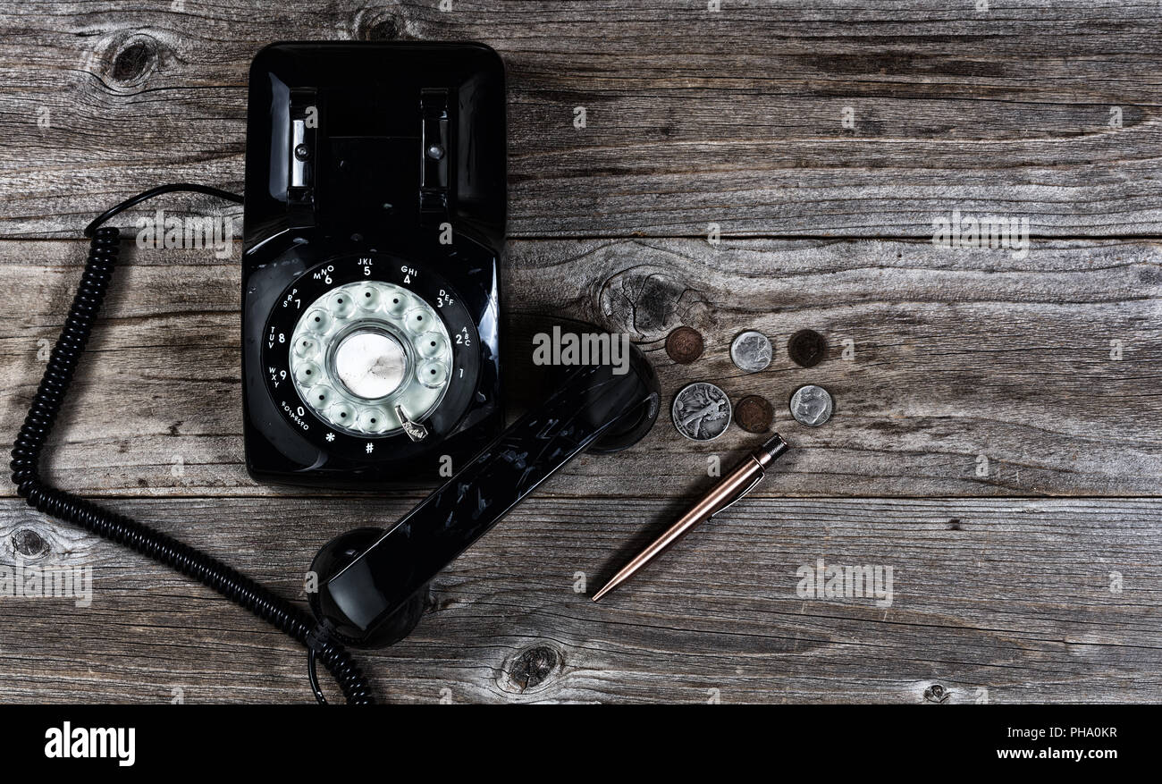Il vecchio telefono con vari vecchi oggetti vintage su ha sottolineato il legno Foto Stock