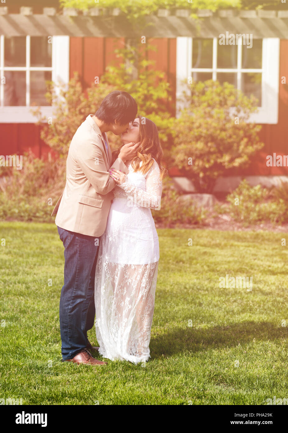 Aspettano di mamma e papà baciare in giornata calda luce all'aperto Foto Stock