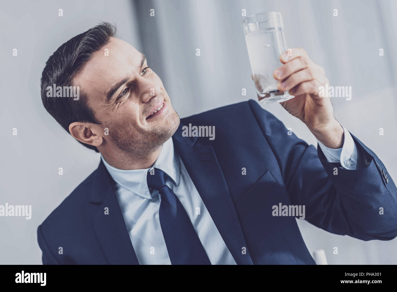 Uomo positivo tenendo un bicchiere di acqua Foto Stock