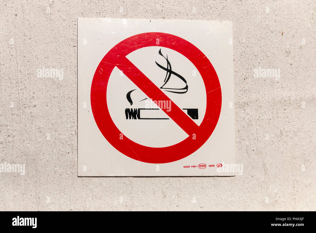Una vista ravvicinata di una per non fumatori segno su un muro bianco Foto Stock