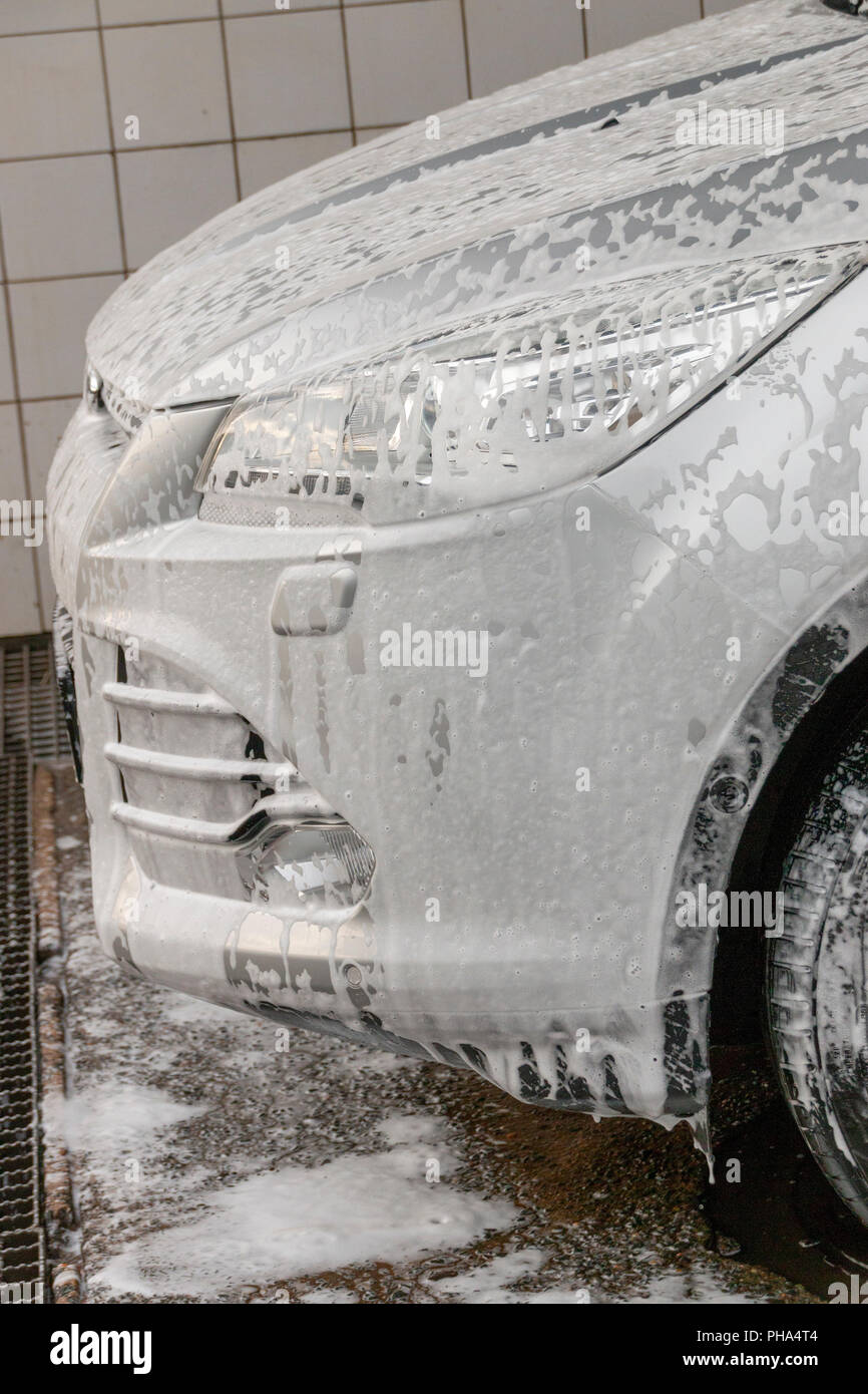 Una vista ravvicinata della schiuma di sapone acceso spento il cofano anteriore e luce laterale di un nastro in auto Foto Stock