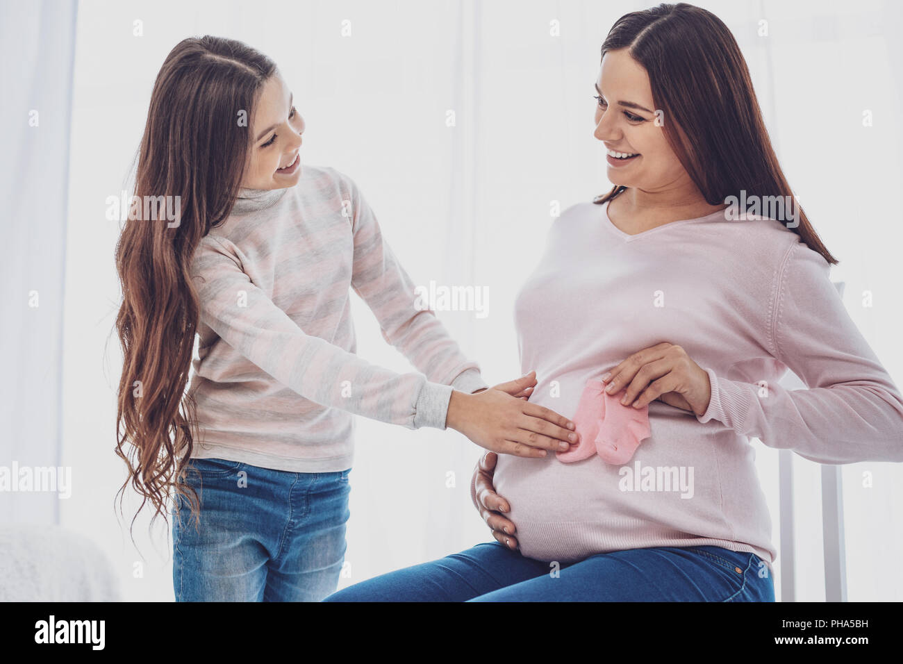Vita di adorabile piccola figlia di toccare il suo ventre delle madri Foto Stock