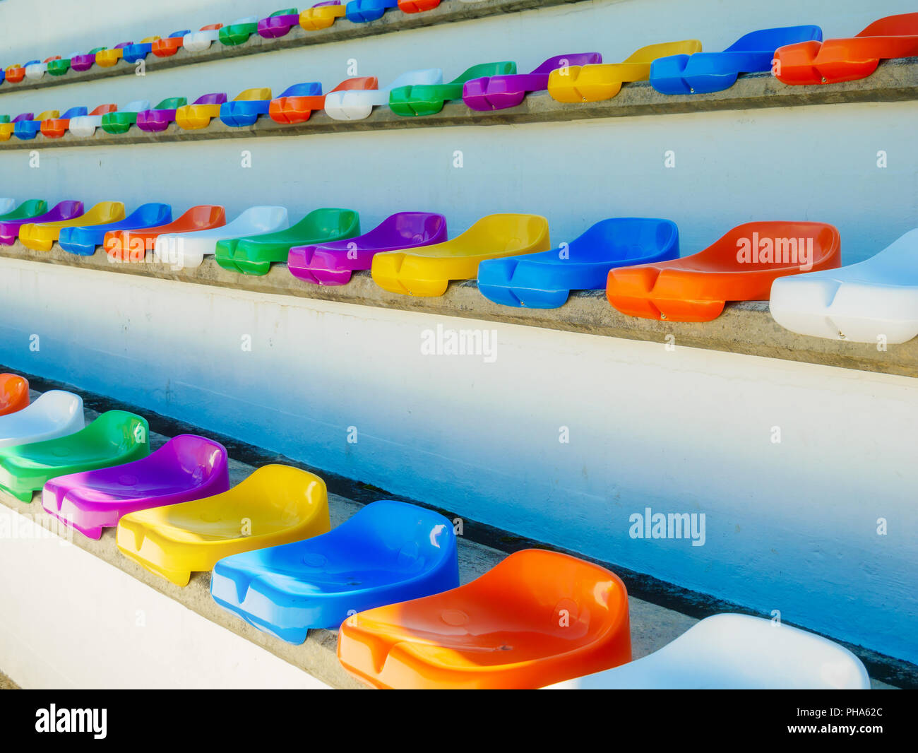 Più file di sedili colorati in un stadion durante il giorno Foto Stock