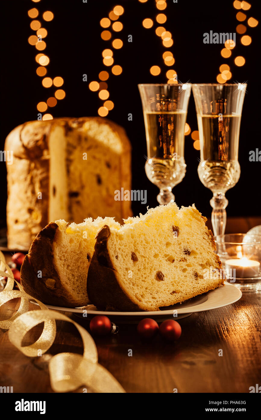 Tagliate a fette il panettone italiano, vino frizzante e decorazioni Foto Stock