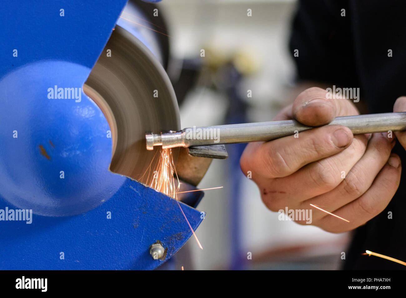 Ingegnere di lavoro sul metallo ad una macchina di rettifica - close-up Foto Stock