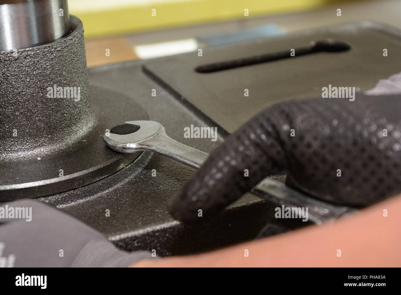 Artigiano tirando la vite di metallo con chiave - close-up Foto Stock