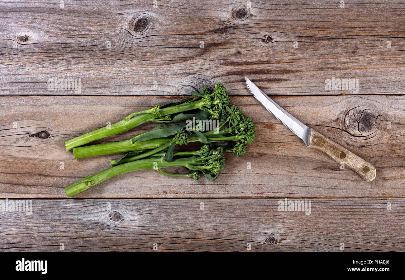 Fresh broccoli cinesi e spelucchino dritto su legno rustico Foto Stock