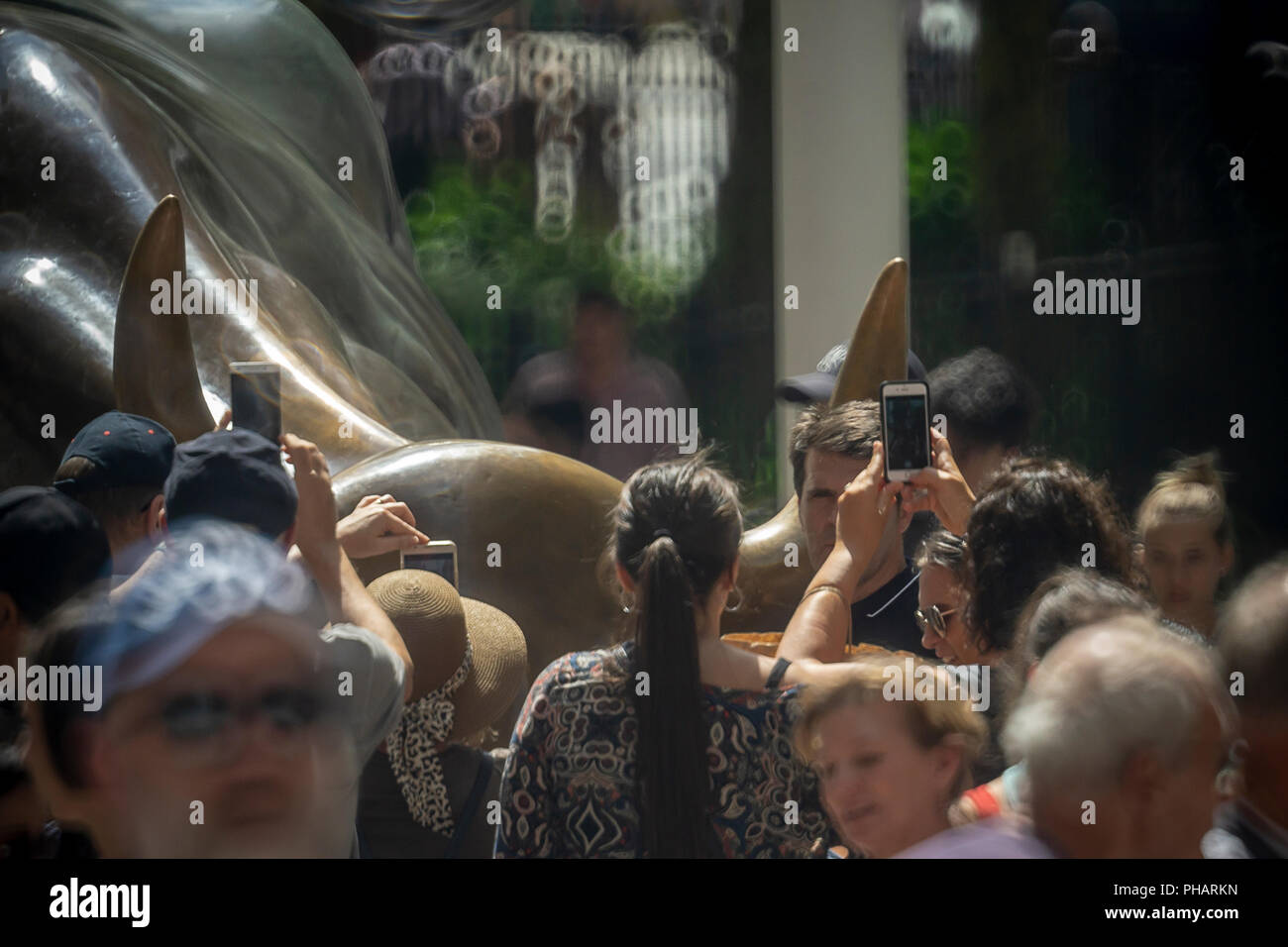 Orde di turisti cluster intorno e posare per le foto di fronte al Wall Street Bull, artista Arturo DiModica, su Broadway in Lower Manhattan a New York il giovedì 30 agosto, 2018. Il mercato azionario è avente la più lunga bull run nella storia, a partire dal 9 marzo 2009 come la grande recessione si è conclusa. (© Richard B. Levine) Foto Stock