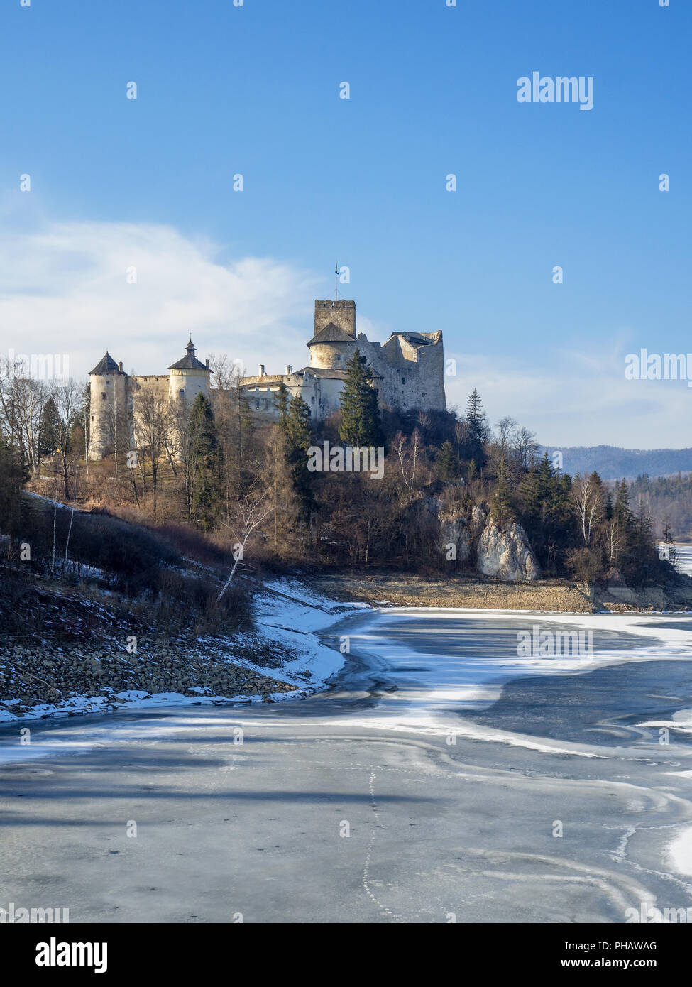 Castello medievale in Niedzica, Polonia, in inverno a parzialmente congelati Czorsztyn artificiale lago sul fiume Dunajec. La luce del tramonto. Foto Stock