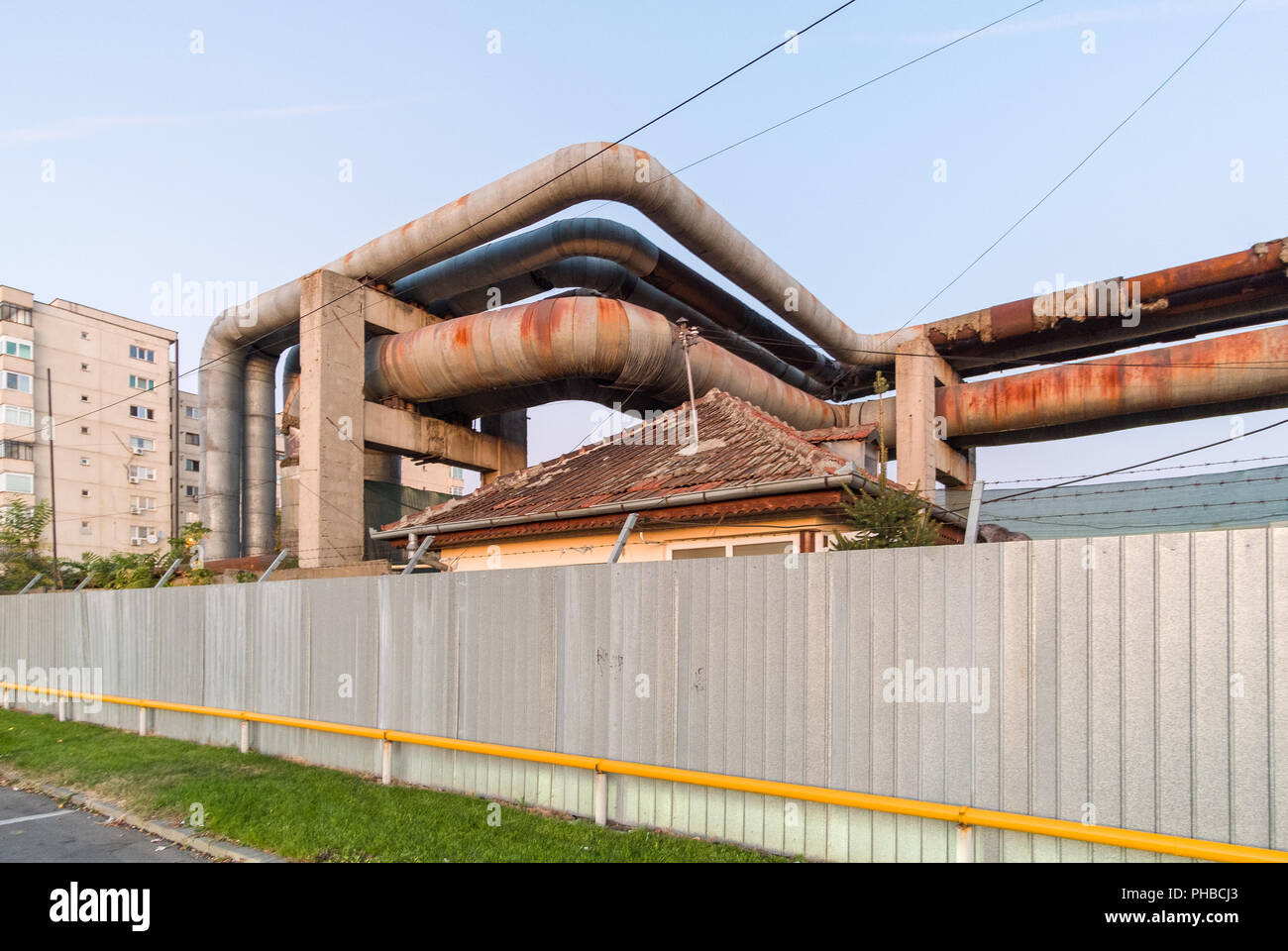 Post decadimento comunista, abbandonati di tubi di riscaldamento al di sopra del tetto di una casa privata nel centro cittadino di Craiova, Romania, UE. Foto Stock