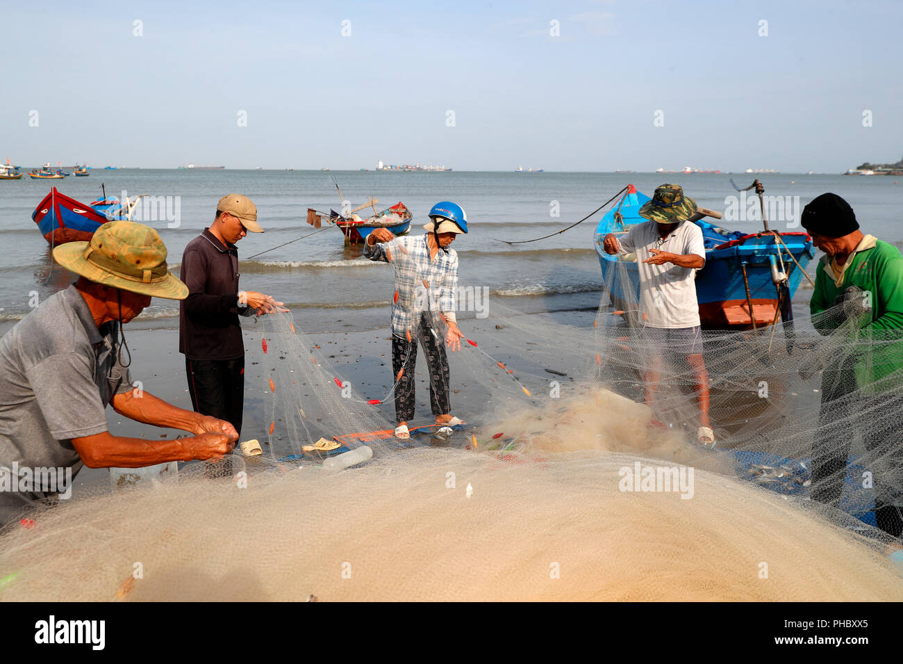 I pescatori la riparazione di reti da pesca a Tam Duong beach, Vung Tau, Vietnam, Indocina, Asia sud-orientale, Asia Foto Stock