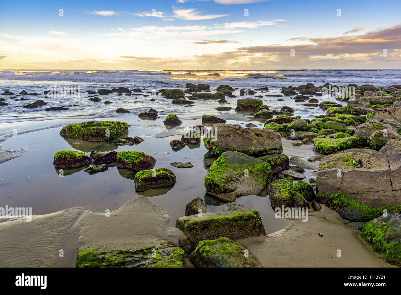 Pietre e acqua con linea di orizzonte della città di Torres Foto Stock