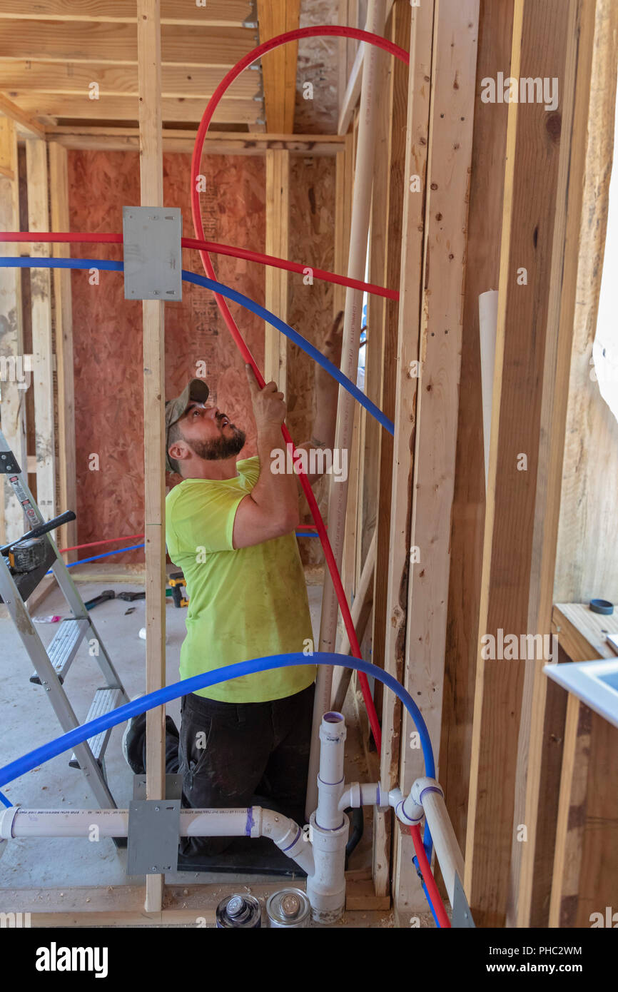 Detroit, Michigan - un idraulico lavora in una piccola casa essendo costruita dalla Comunità Cass servizi sociali per i senzatetto. L'organizzazione no-profit che intende eventualmente Foto Stock