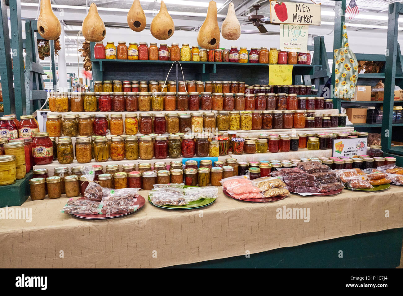 Interno del cordolo di mercato coperto di un azienda o di un mercato agricolo con vasi di fresco di vibra frutta e verdura marmellate e gelatine sul display in Montgomery AL USA. Foto Stock