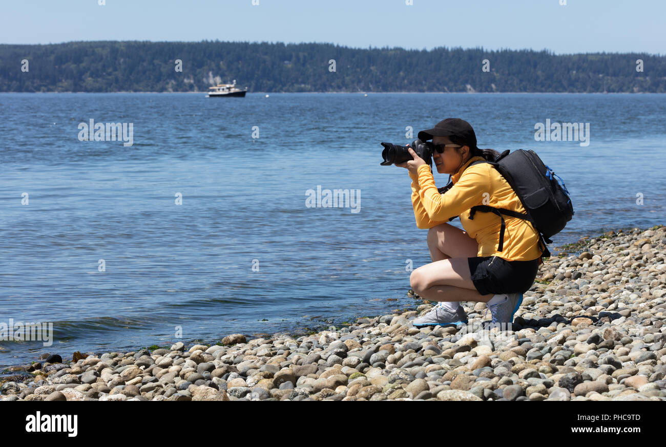 Donna fotografo di natura lavorando sulle foto vicino al litorale del mare Foto Stock