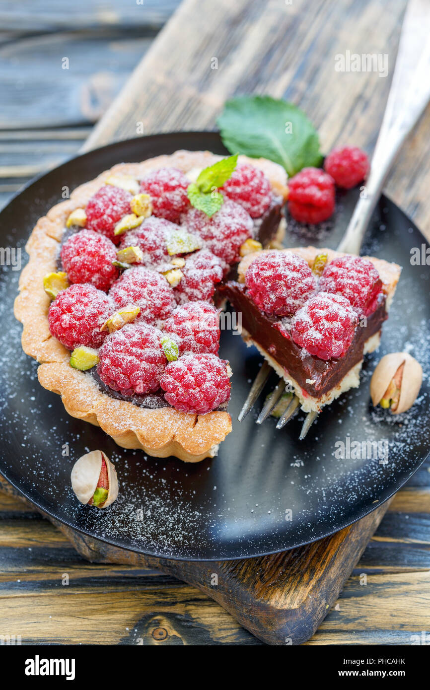 Tartlet con lamponi e la forcella sulla piastra. Foto Stock