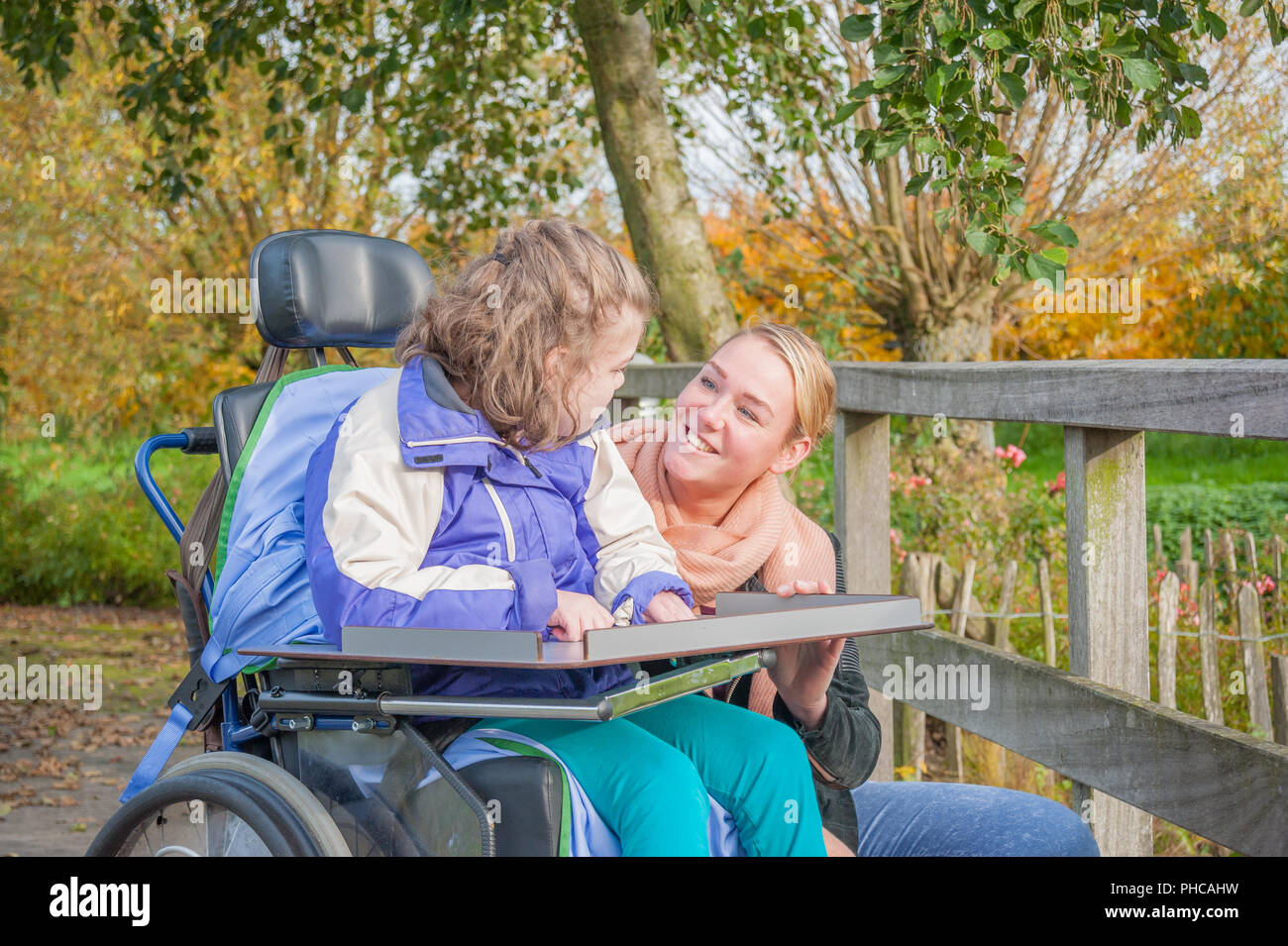 Un bambino disabile essendo curata da una speciale ha bisogno di accompagnatore Foto Stock