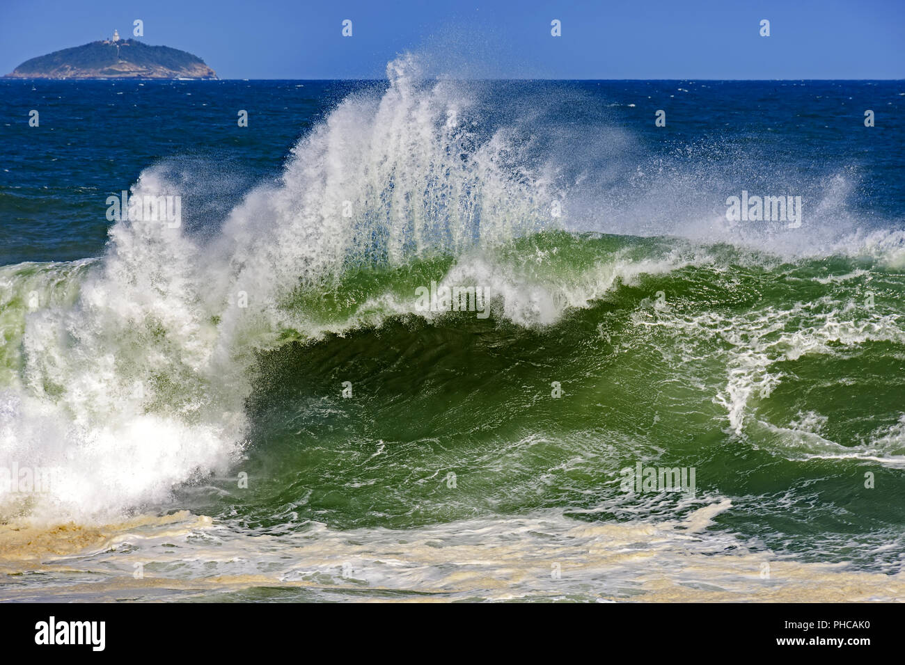 Onde tempestose con isola in orizzonte Foto Stock