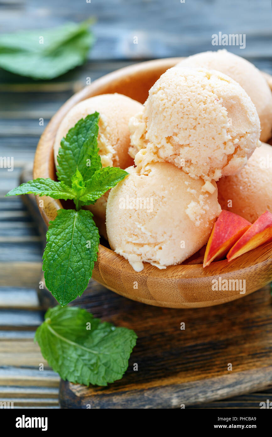 Peach gelato e fette di pesche fresche nella ciotola. Foto Stock