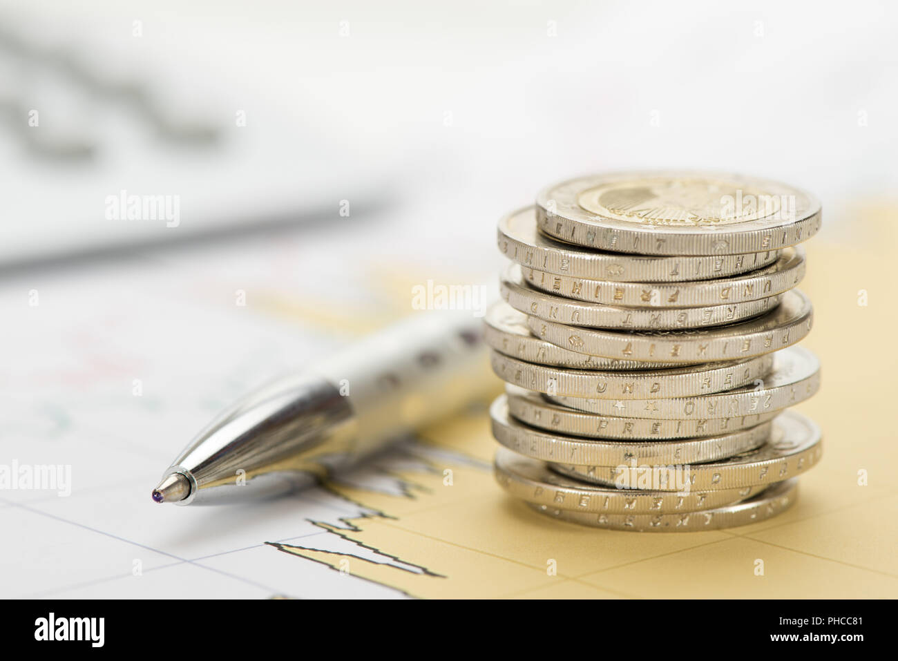 Impilati monete in euro con dati e grafico del mercato dei cambi Foto Stock