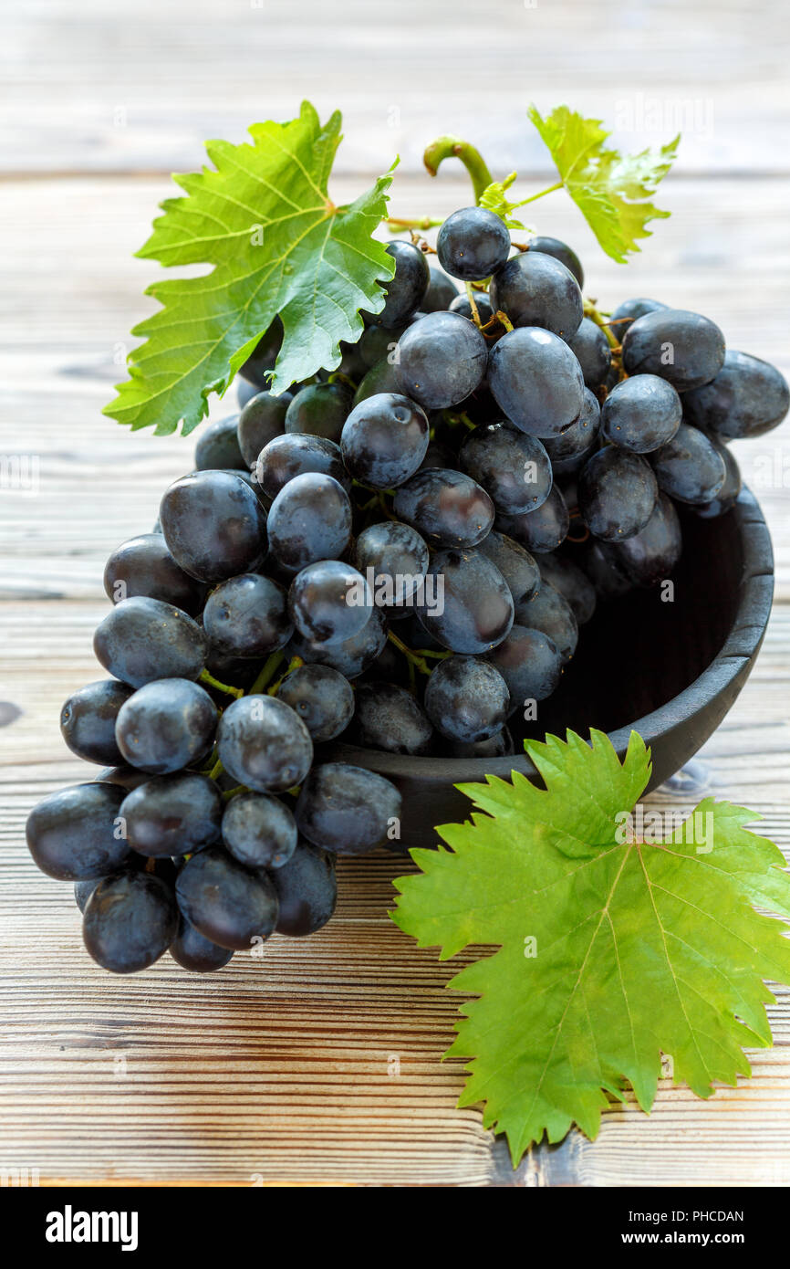 Mature uve nere nella vecchia ciotola. Foto Stock