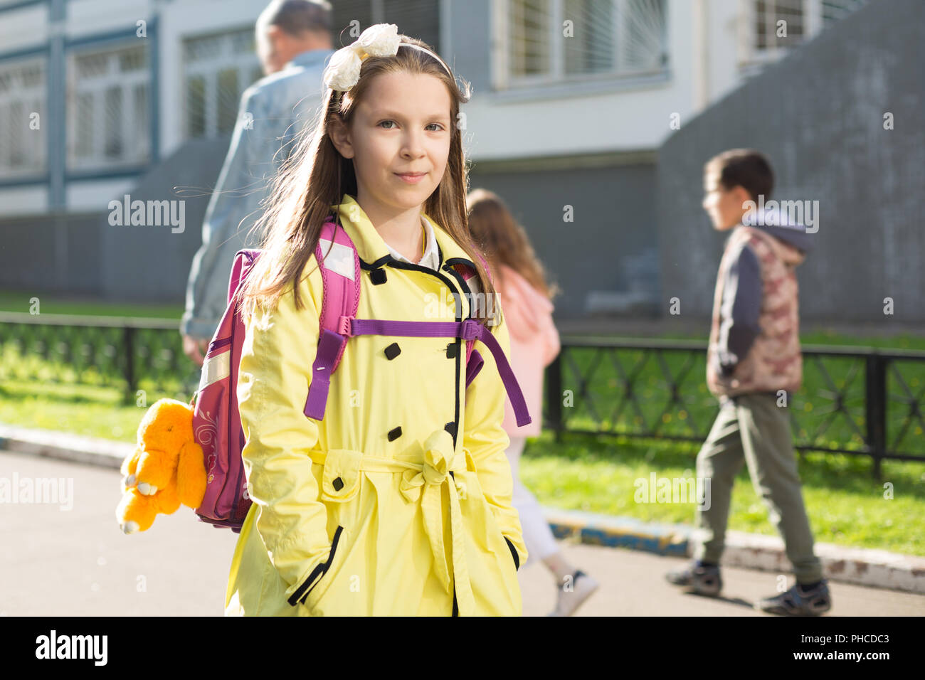 Schoolgirl nel rivestimento di colore giallo Foto Stock