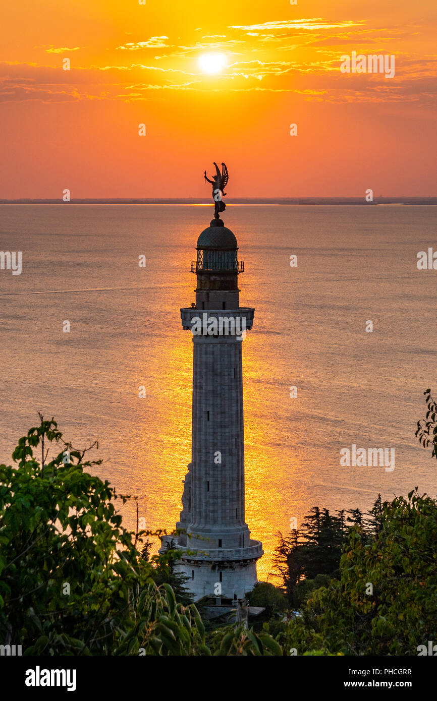 Trieste, 19 agosto 2018. Trieste il Faro della Vittoria faro) al tramonto. La Vittoria Alata (Vittoria alata) statua in bronzo su Foto Stock