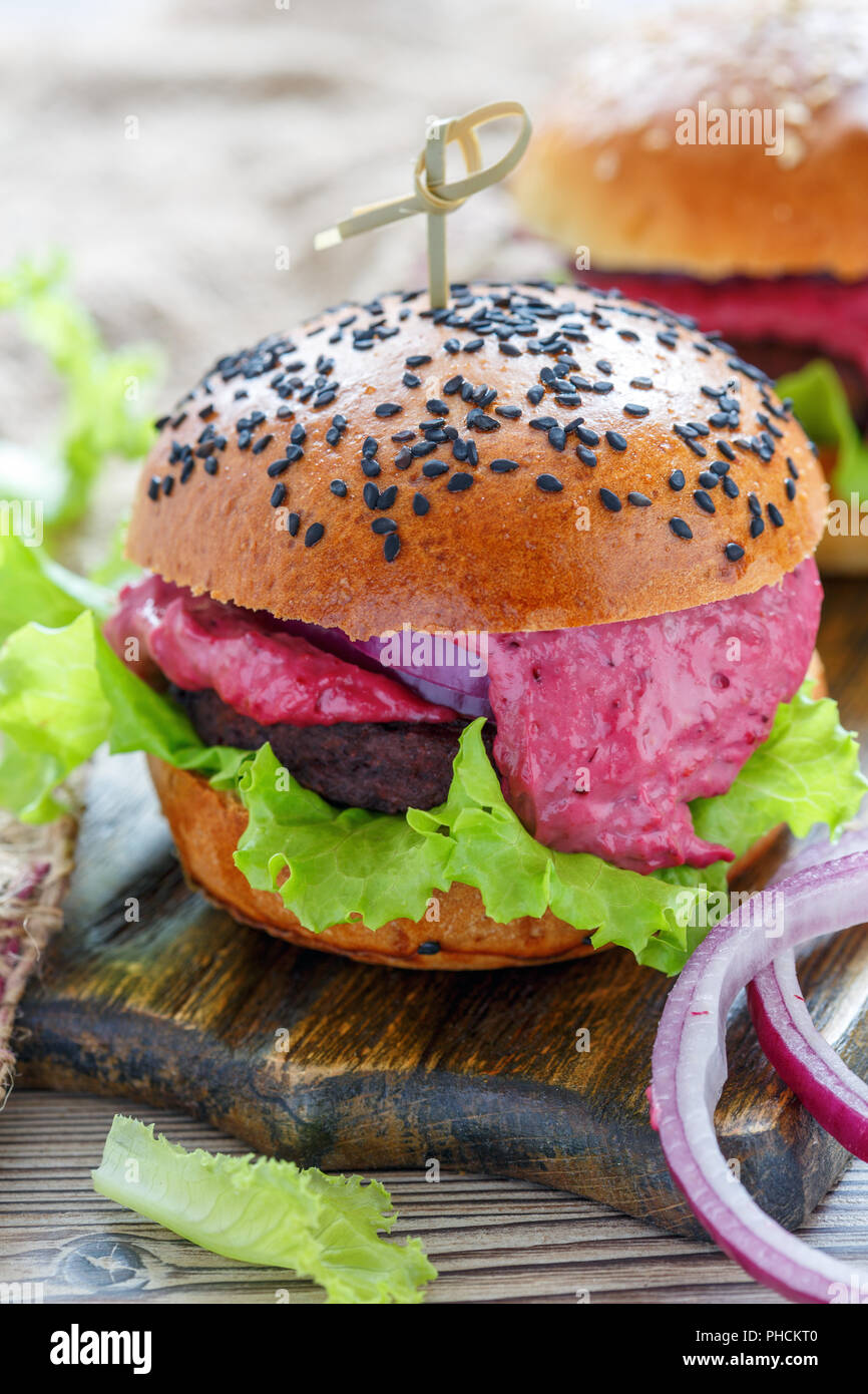 Burger con carne di manzo, insalata e salsa di frutti di bosco. Foto Stock