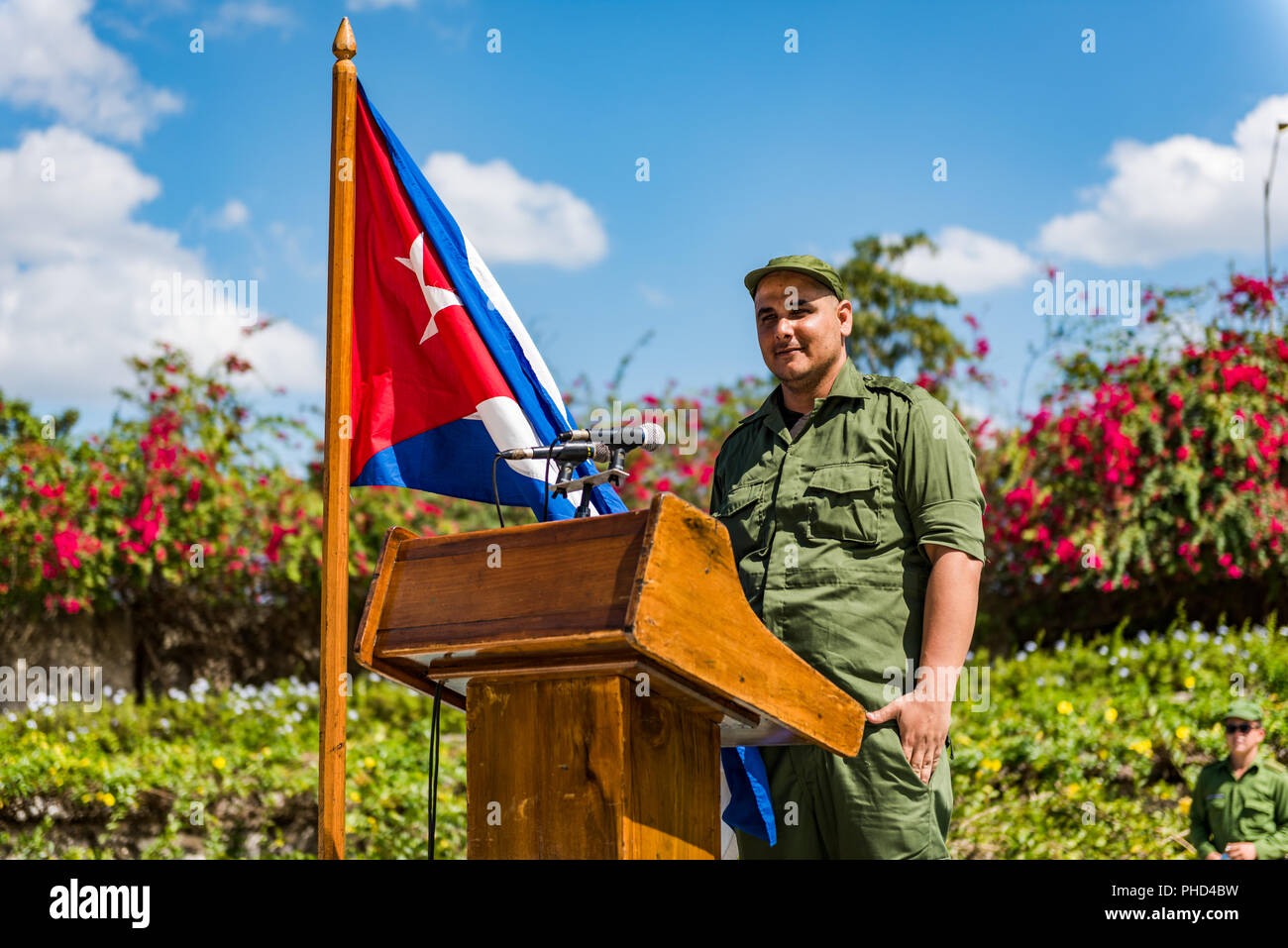 Soldato cubano sta al podio con la bandiera cubana in preparazione per la realizzazione di un intervento. Foto Stock